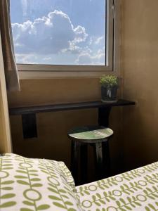 Rooftop apartment front Boudha View في كاتماندو: غرفة نوم بها سرير وطاولة ونافذة