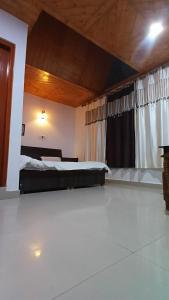 Un dormitorio grande con una cama y una ventana. en Dreamcatcher Homestay, en McLeod Ganj