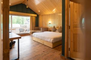 Un dormitorio con una cama y un balcón. en Hotel Patalsu, en Palchān