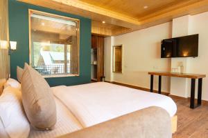 a bedroom with a large white bed and a window at Hotel Patalsu in Palchān