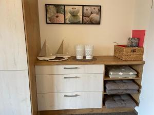 巴尔特鲁姆Dünenhus Wohnung 2的房间里有一个梳妆台，架子上放着毛巾。