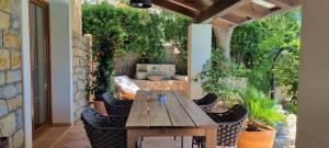 eine Terrasse mit einem Holztisch und Stühlen in der Unterkunft Villa Rapkinja in Mundanije