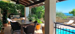 eine Terrasse mit Tisch und Stühlen und Blick auf das Meer in der Unterkunft Villa Rapkinja in Mundanije