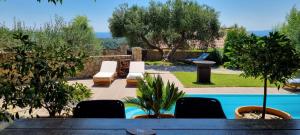 eine Terrasse mit Tisch und Stühlen und einem Pool in der Unterkunft Villa Rapkinja in Mundanije