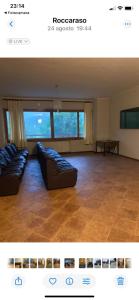 a living room with couches in a room with windows at Relax House in Roccaraso