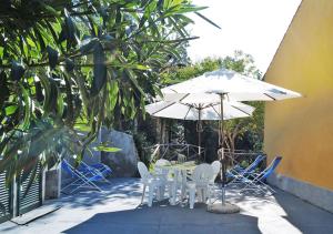 a table and chairs and an umbrella in a courtyard at Sansone Sul Mare Appartamenti in Portoferraio