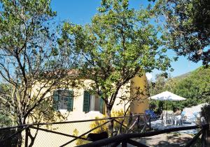 a house with a fence and a table and an umbrella at Sansone Sul Mare Appartamenti in Portoferraio