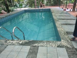 een leeg zwembad met groene tegels op de bodem bij 2 Bedroom villa in Mūvattupula