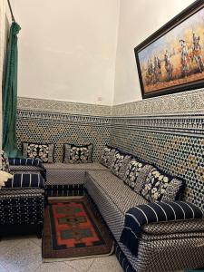 a living room with a couch and a painting on the wall at Maison EZ in Rabat