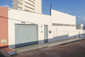 a white building with two doors on the side of it at CS1 - Ampla Casa com ArCond e Lazer Completo in Juazeiro do Norte