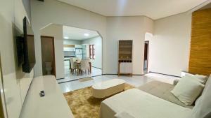 a bedroom with a bed and a living room at CS1 - Ampla Casa com ArCond e Lazer Completo in Juazeiro do Norte