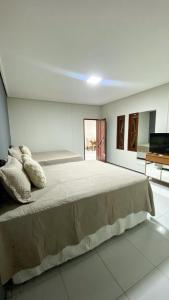 a bedroom with a large bed with pillows on it at CS1 - Ampla Casa com ArCond e Lazer Completo in Juazeiro do Norte
