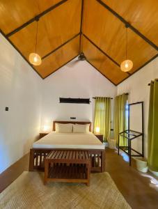 蒂瑟默哈拉默Dairy Farm Cottage Weerawila的带一张大床和木质天花板的卧室