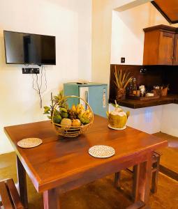 蒂瑟默哈拉默Dairy Farm Cottage Weerawila的一张木桌,上面有一篮水果 更多6张照片