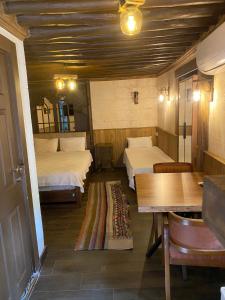 a room with two beds and a table and chairs at Yılmazhan Konağı Butik Otel in Gaziantep