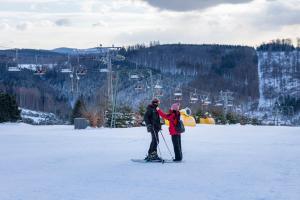 two people on skis in the snow on a ski lift at Residences Central Winterberg in Winterberg +71 photos