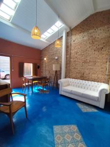 瓜拉雷马Charmosa casa na Estação Ferroviária de Luís Carlos的客厅配有白色沙发和砖墙