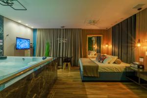 a hotel room with a bed and a tub at Florence Motel Spa - Santa Rosa-RS in Santa Rosa