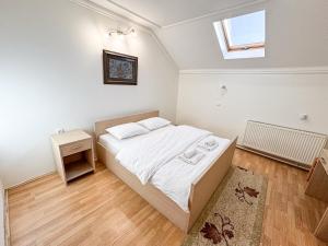 a small bedroom with a bed and a window at Guest house Vila Bor in Novi Sad