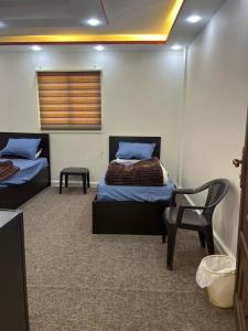 a room with two beds and a chair in it at Rum Awaad luxury camp in Wadi Rum +36 photos