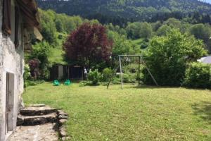 un cortile con un'altalena nell'erba di Charmante maison familiale a Saint-Pierre-de-Chartreuse