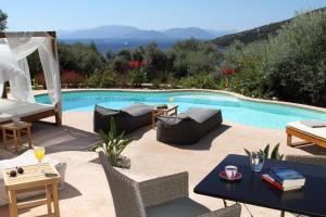 un patio con piscina, mesa y sillas en Villa Agapi Spacious Stone Retreat with Jacuzzi and Private Pool, en Sivota