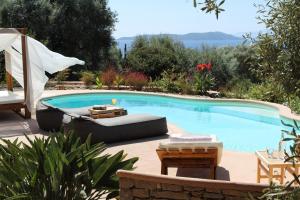 una piscina con sofá y sillas junto a ella en Villa Agapi Spacious Stone Retreat with Jacuzzi and Private Pool, en Sivota 52 fotos más