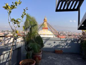 a view of a tower from a balcony with plants at Rooftop apartment front Boudha View in Kathmandu