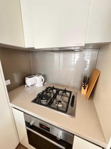 a kitchen with a stove top oven in a kitchen at 1Br City View apt near SthnCrs Wifi Pool Gym in Melbourne +1 photo