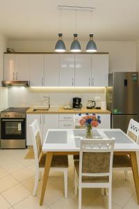 - une cuisine avec une table et des chaises blanches dans l'établissement ALBis apartments 1, à Tirana