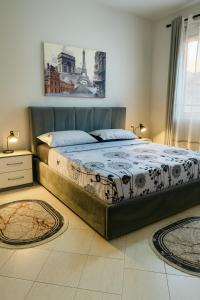 - un grand lit dans une chambre avec 2 tapis dans l'établissement ALBis apartments 1, à Tirana