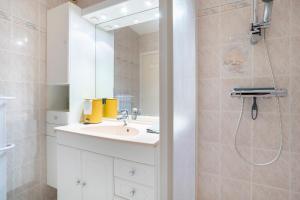 ein weißes Badezimmer mit Waschbecken und Dusche in der Unterkunft Ty Corniche - 50m de la plage in Bénodet + 16 Fotos