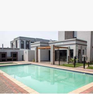 a house with a swimming pool in front of it at Reamo Suites in Gaborone