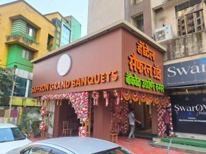 een man die voor een winkel staat bij Hotel Saffron Grand Thane in Thane