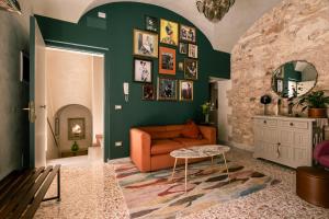 a living room with an orange couch and green walls at Da Leah in Ragusa