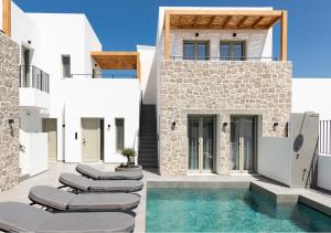 a villa with a swimming pool and lounge chairs at Kalea Suites in Pollonia