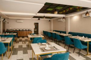 Un comedor con mesas y sillas azules. en Hotel Golden Temple View - Best Property of Amritsar 2024-25, en Amritsar