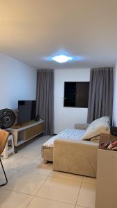 une chambre avec un lit et une télévision dans l'établissement Apartamento próximo a praia, à Maceió