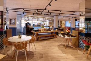 un restaurant avec des tables et des chaises et une cuisine dans l'établissement Radisson Hotel Aix En Provence, à Aix-en-Provence