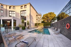 un patio avec des chaises et une piscine dans l'établissement Radisson Hotel Aix En Provence, à Aix-en-Provence