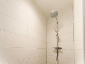 a shower with a shower head in a bathroom at Serene Holiday Home in De Koog Texel with Sauna in Westermient