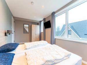 a bedroom with a bed and a large window at Serene Holiday Home in De Koog Texel with Sauna in Westermient +29 photos