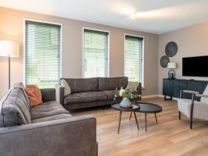 a living room with a couch and a tv at Serene Holiday Home in De Koog Texel with Sauna in Westermient