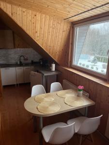 une table et des chaises dans une cuisine avec une fenêtre dans l'établissement KRI Holiday House, à Alūksne 14 autres photos