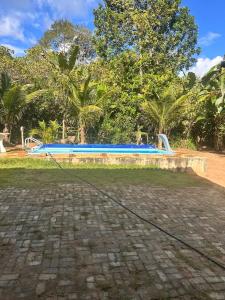 a blue bench in front of a swimming pool at Chalé Canto dos Pássaros in Viçosa do Ceará