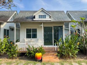 ein weißes Haus mit einer Veranda und Glastüren in der Unterkunft Pophouse in Phetchaburi + 11 Fotos