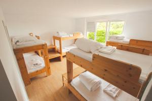 a room with four bunk beds and a window at Latas Surf House in Somo