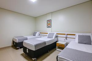 a hospital room with three beds in it at OYO Tropical Confort Hotel, Brasilia in Brasília