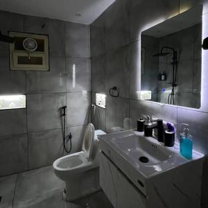 Un baño con lavabo, inodoro y espejo. en ميامي هوستيل, en Kuwait
