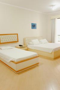 two beds sitting in a room with at Rovi Plaza Hotel in Serra Negra